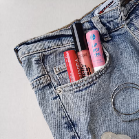 Lip care products tucked into a denim pocket