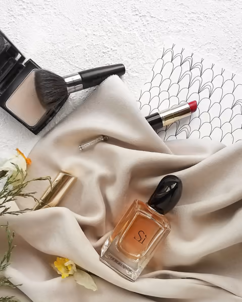 Cosmetics and a brush arranged on cream silk